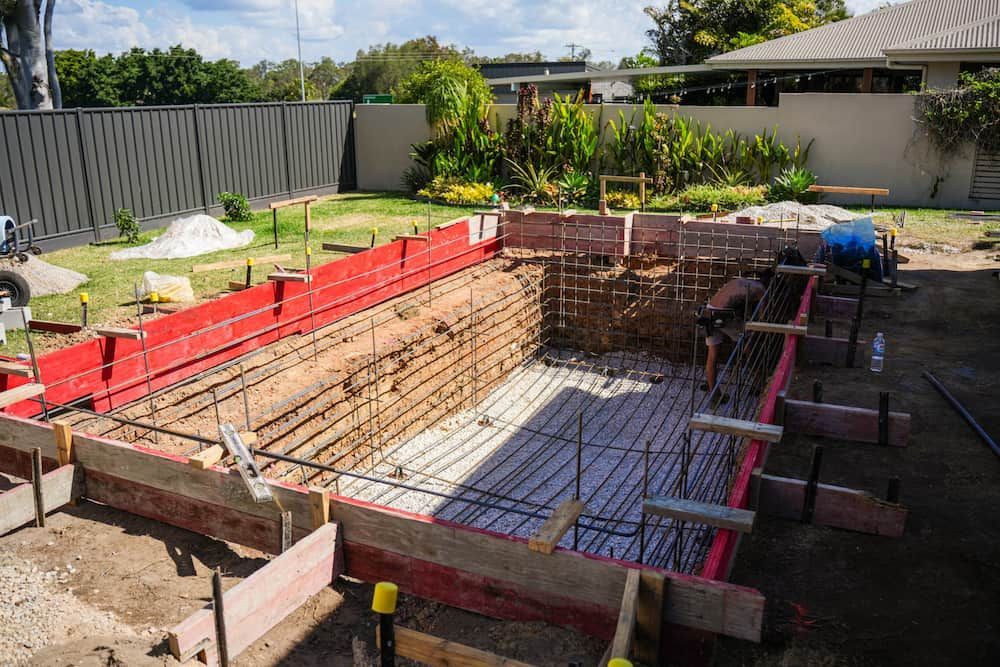 Lounge Chairs on Grass Beside a Swimming Pool — Concrete Pool Projects in Mount Larcom, QLD