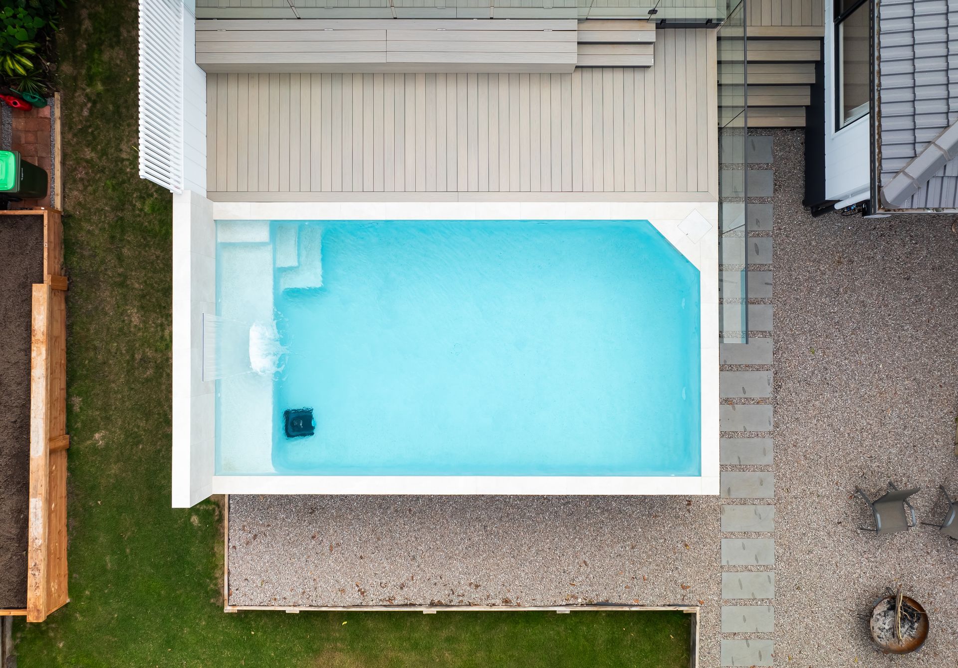 Sandy Beach With Dark Rocks and Blue Water — Concrete Pool Projects in Tannum Sands, QLD