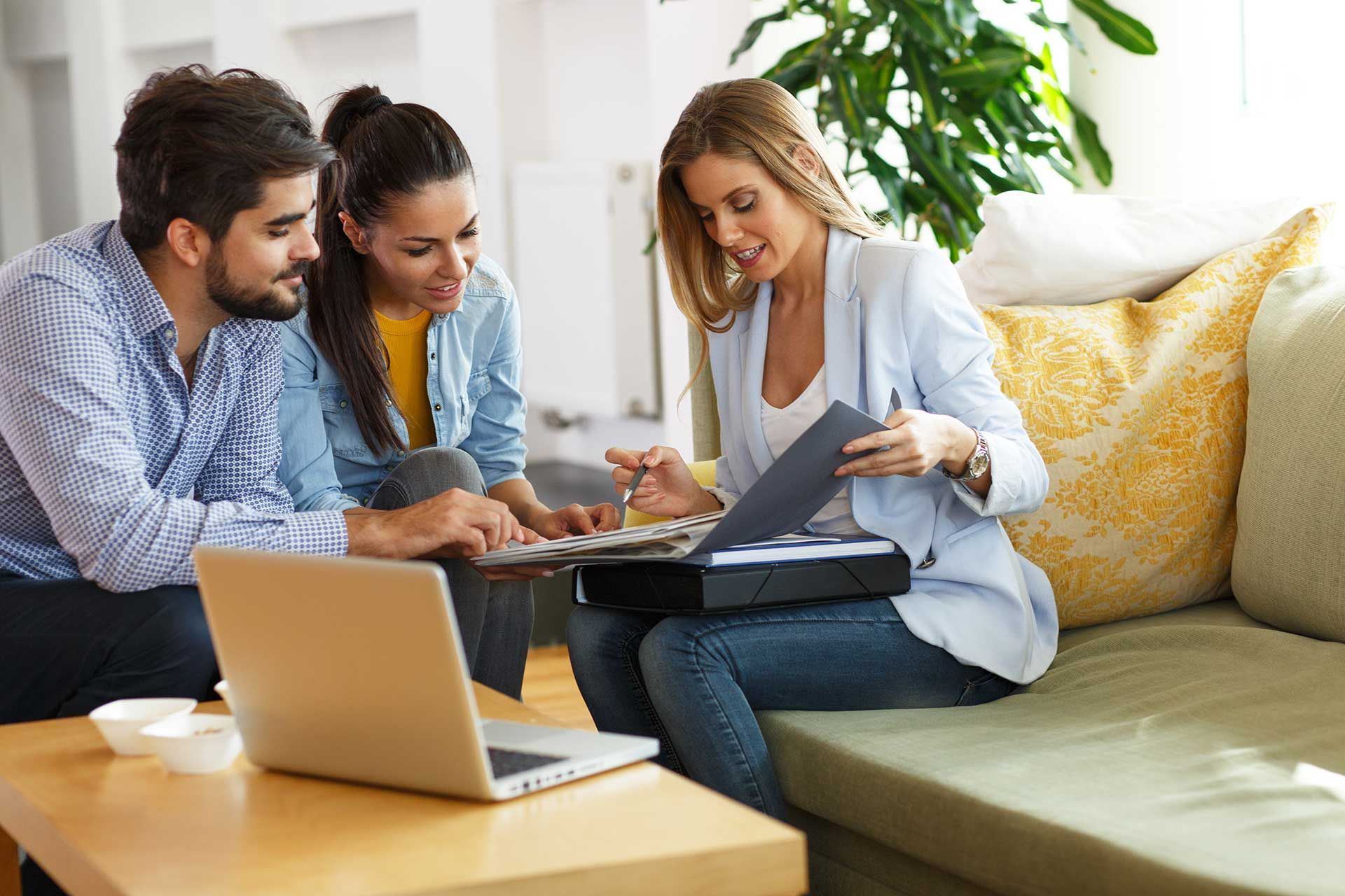 Female real estate agent offer homeownership and life insurance to young couple.