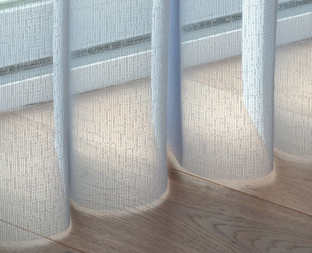 White sheer curtains hang, casting shadows on a light wood floor.