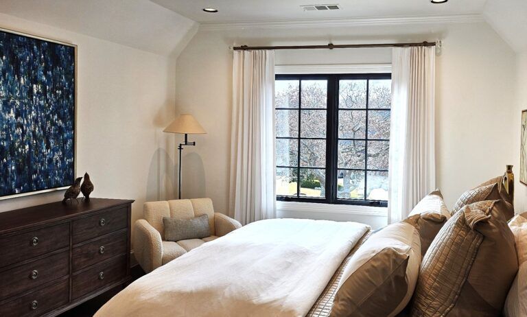 Bedroom with a bed, dresser, chair, window, and large blue abstract painting.