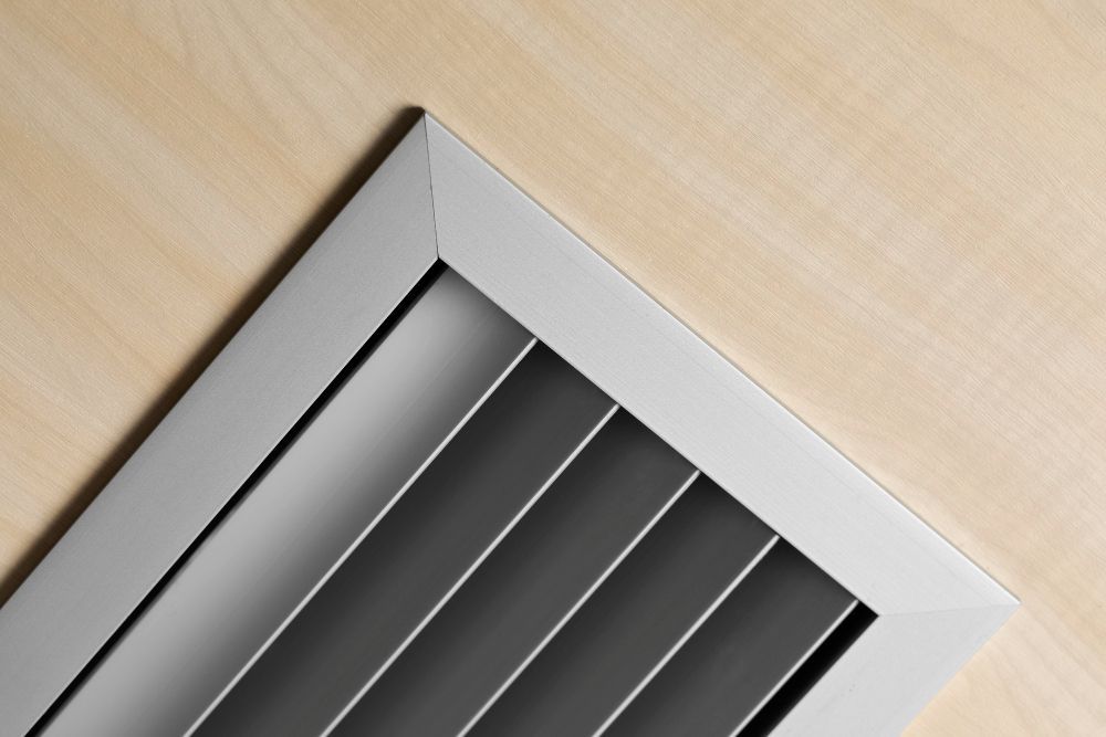a close up of a metal grille on a wooden surface