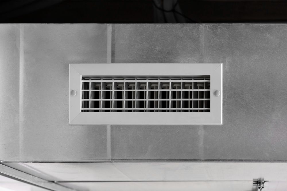a gray wall with a white grille on it