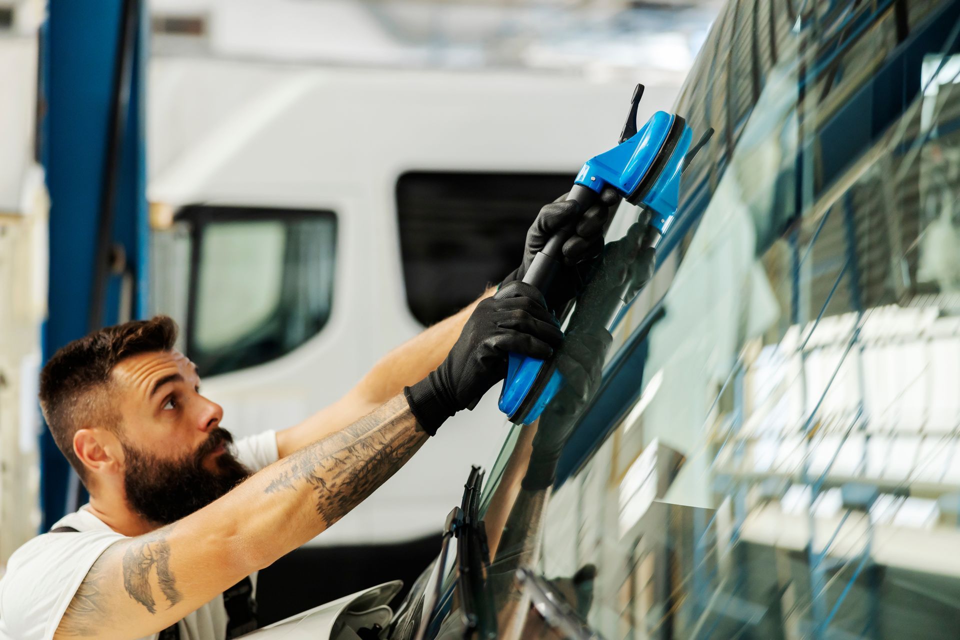 A mechanic is working on the windscreen of a bus. A mechanic is working on the windscreen of a bus.