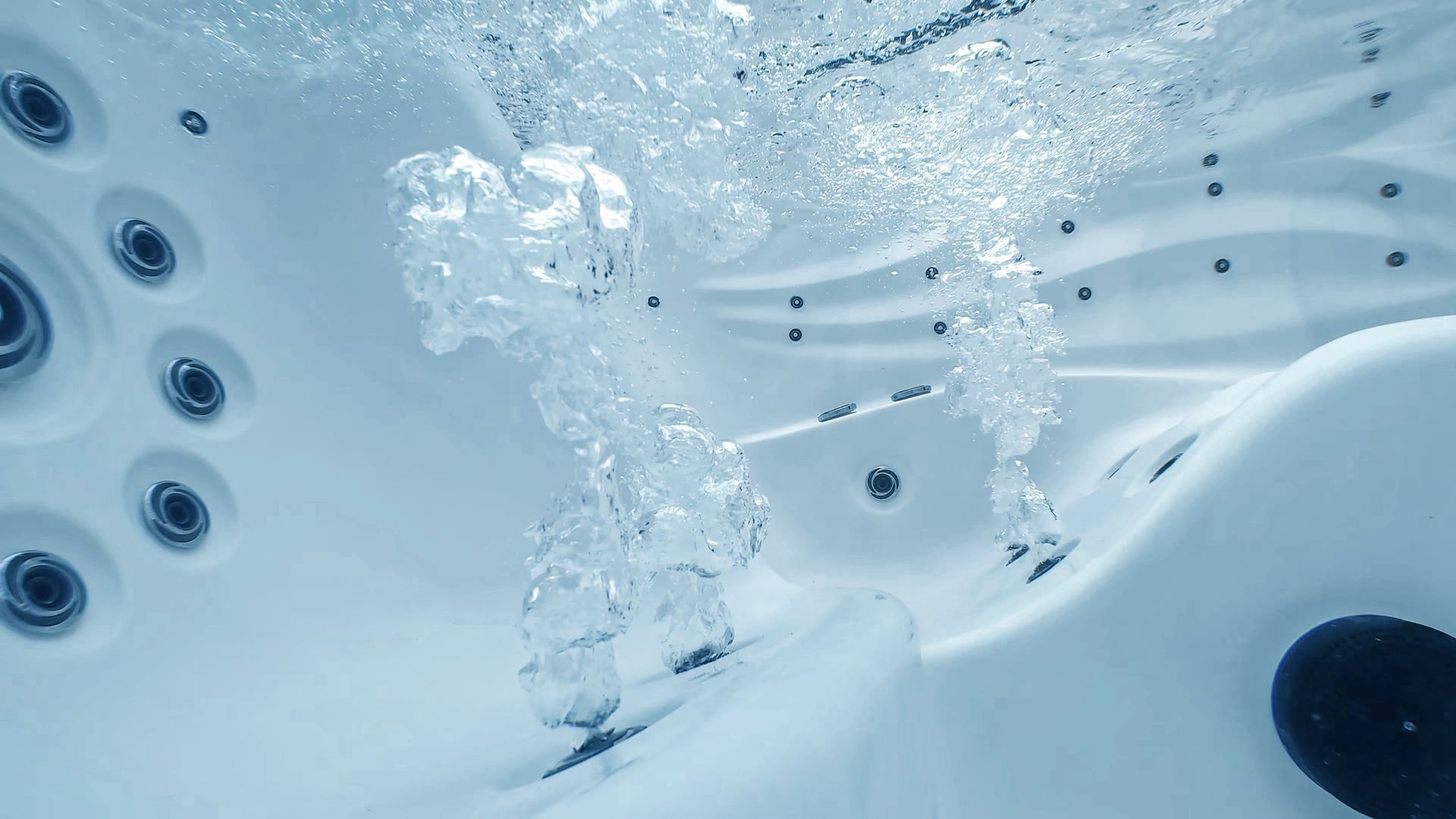 Blue hot tub water with swirling bubbles and jets