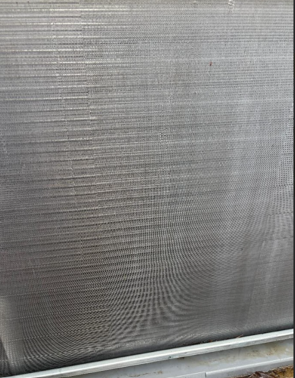 Close-up of a gray textured metal mesh panel with a white frame at the bottom.