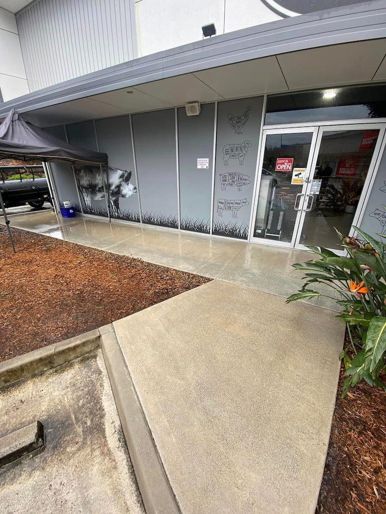 a pressure washed gold coast store front with a sign that says open