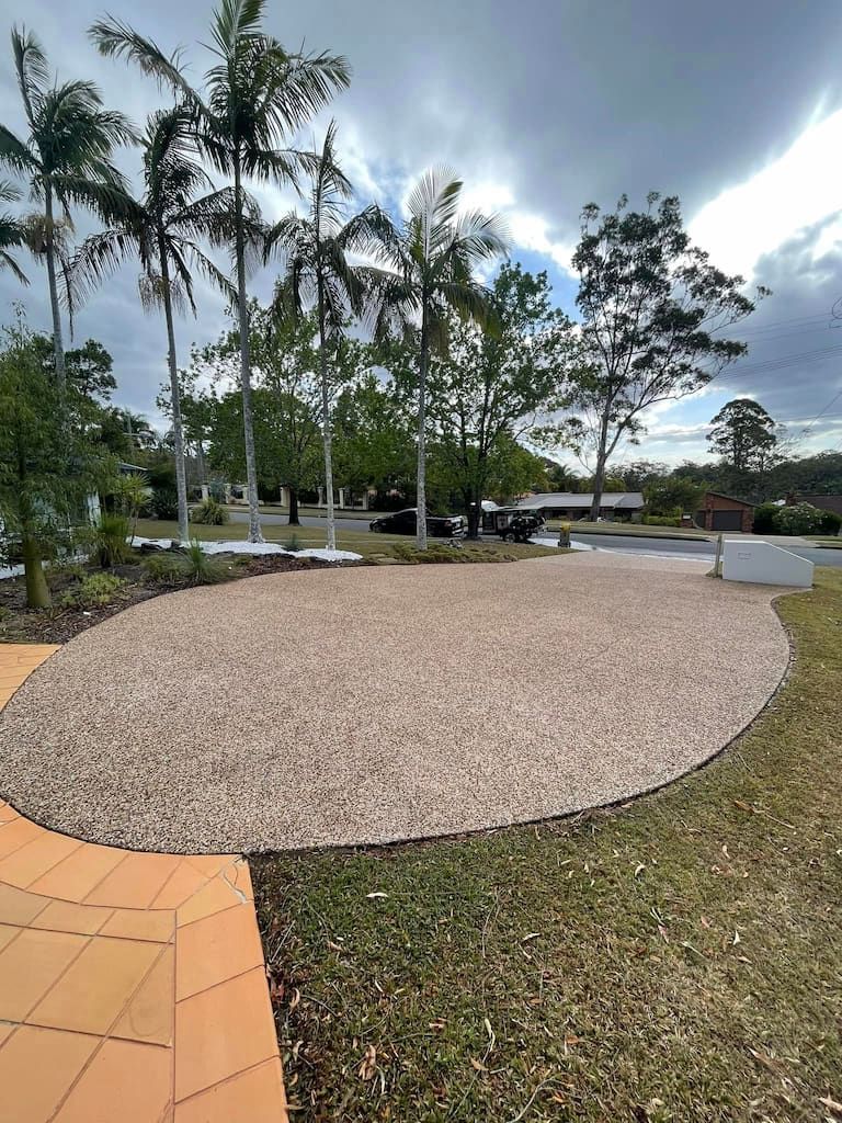 a gravel driveway that was pressure washed with palm trees in the background