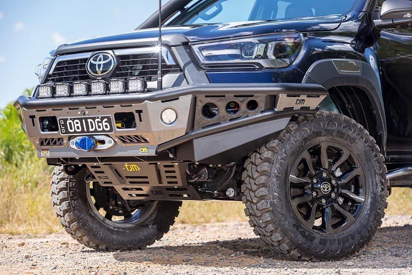 A Black Toyota Hilux is Parked on a Dirt Road — Lacey's TJM 4X4 Megastore in Rockhampton City, QLD