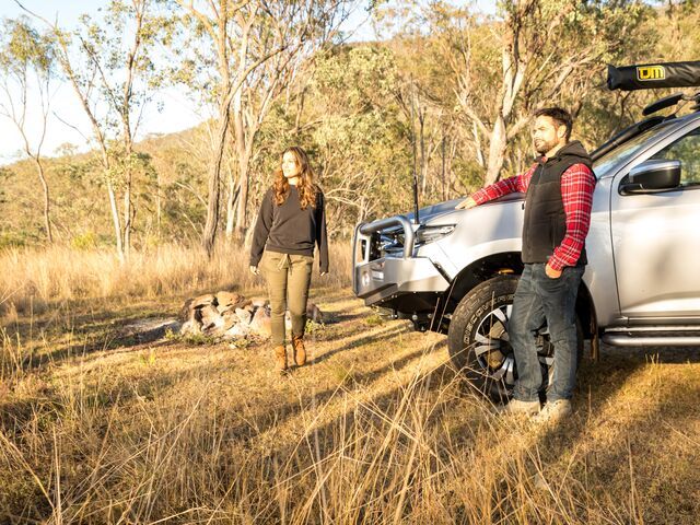 A Man Leans Against a Silver Suv in A Grassy Field — Lacey's TJM 4X4 Megastore in Rockhampton City, QLD