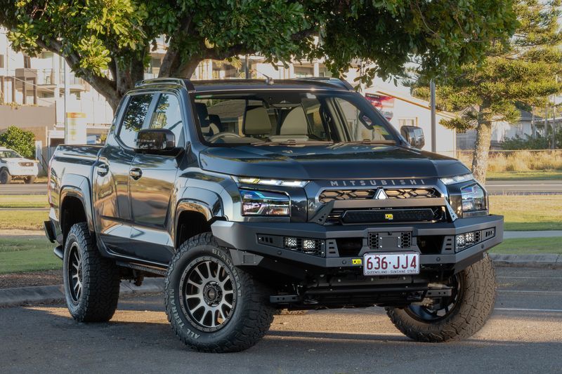A Black Truck Is Parked in A Carpark Near a Park — Lacey's TJM 4X4 Megastore in Rockhampton City, QLD