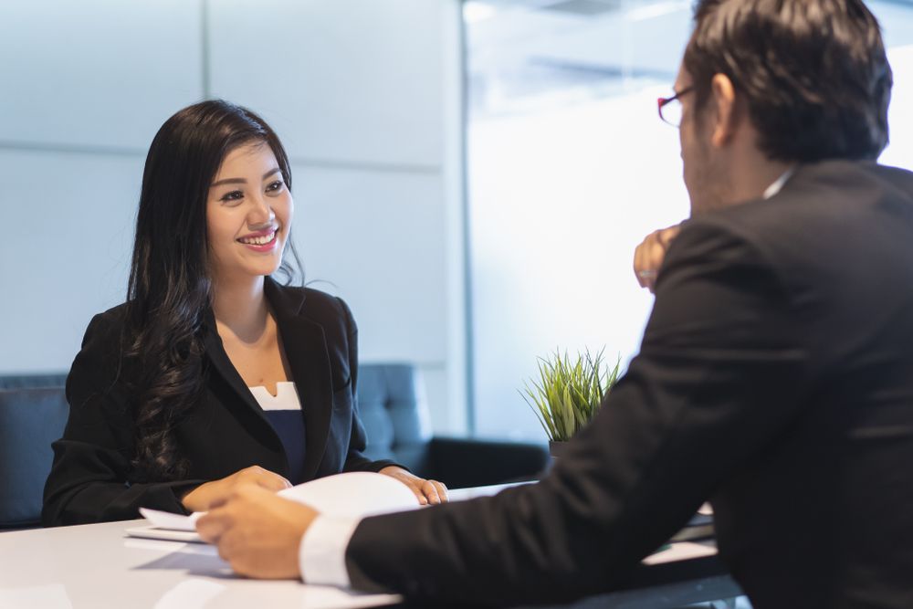 A man and a woman are sitting at a table having a conversation.