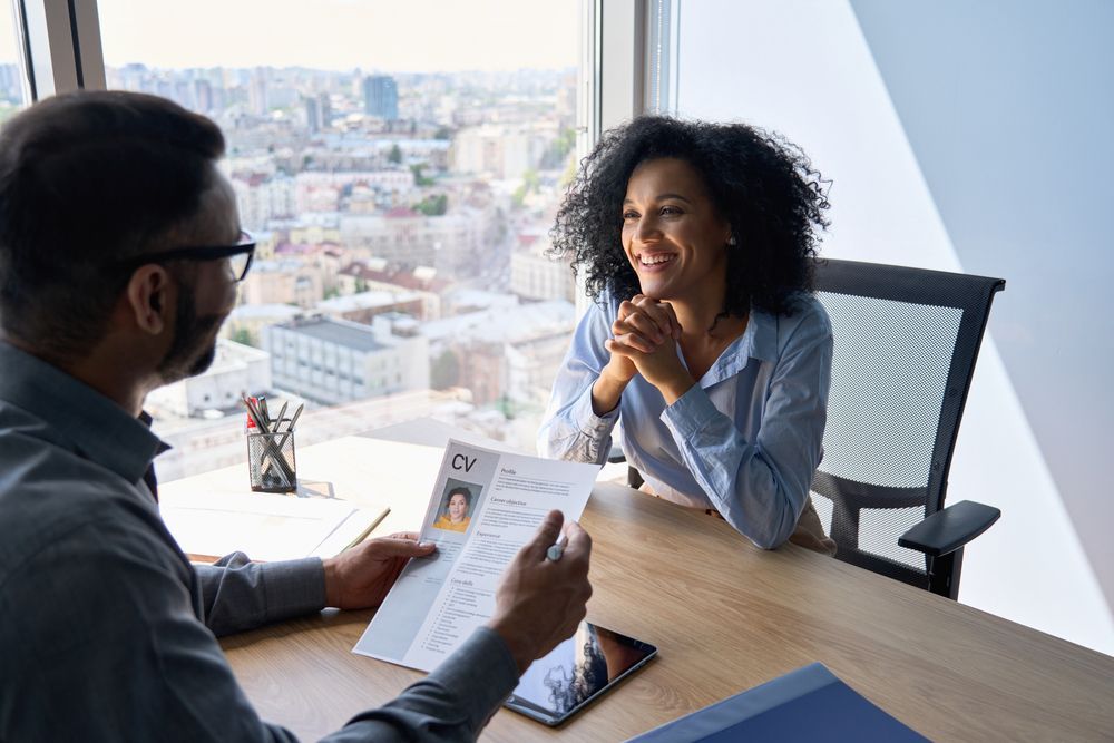 A man and a woman are sitting at a table having a job interview.