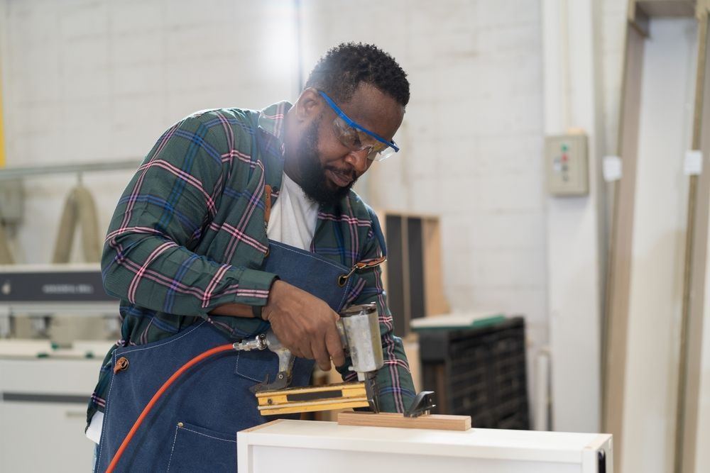 A man is working on a piece of wood in a workshop.
