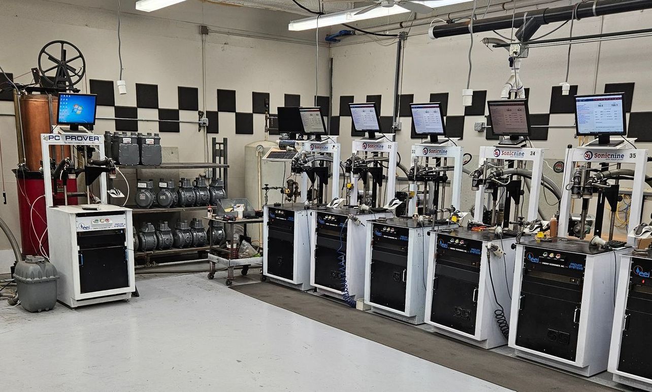 Laboratory with multiple testing stations featuring computers, machinery, and a checkered pattern on the wall.