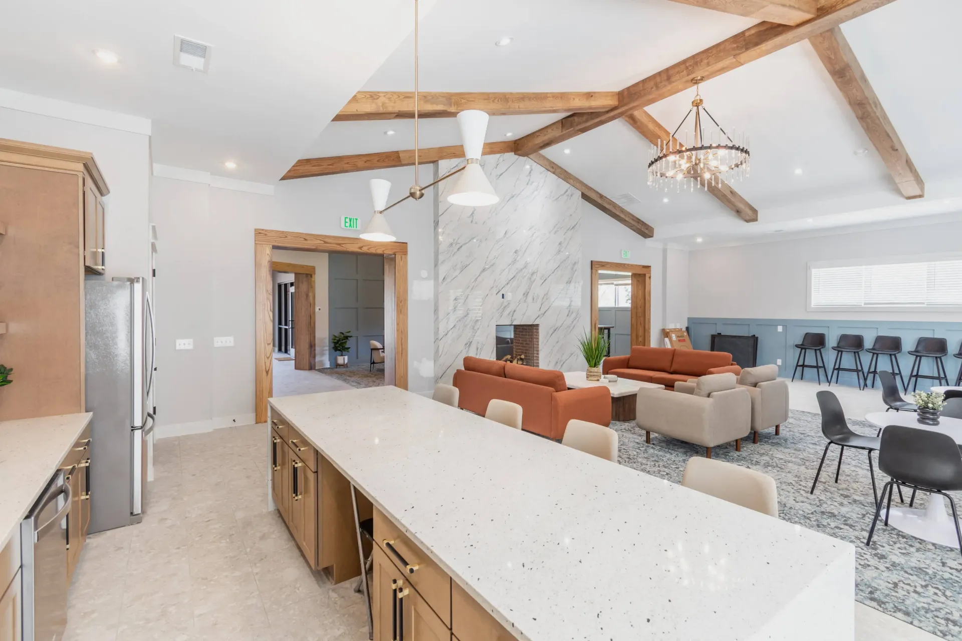 Spacious communal lounge area with a large kitchen island, seating areas, and a fireplace.