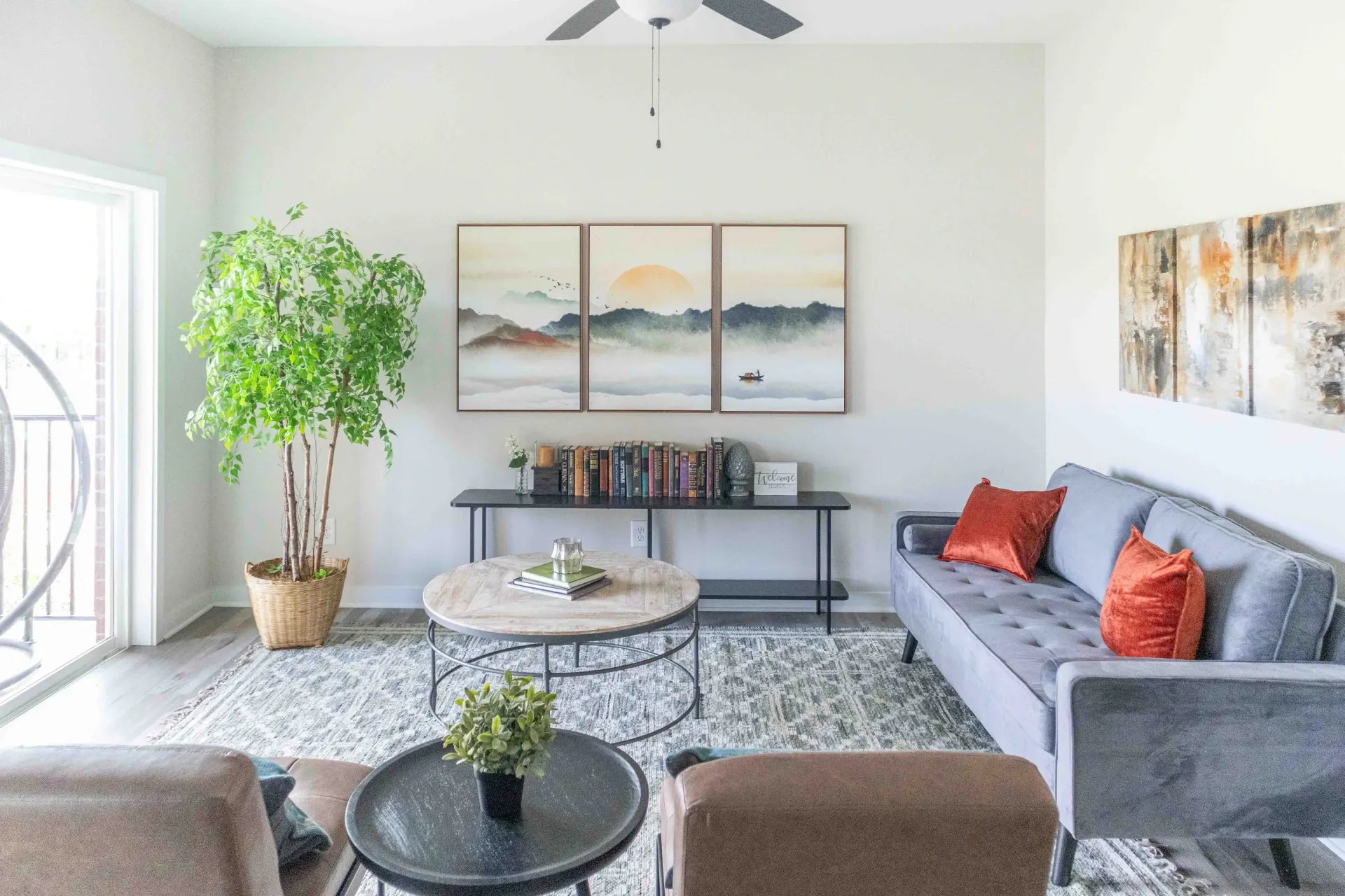 Living room with grey sofa, coffee tables, and large plant.