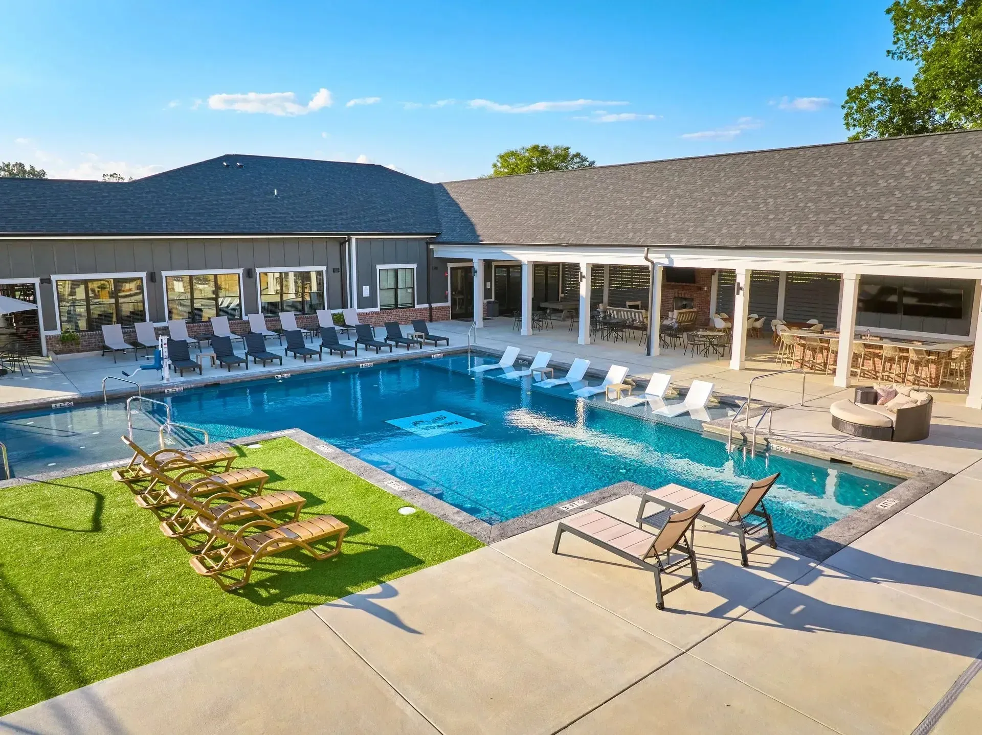 Luxury swimming pool area with lounge chairs and cabanas