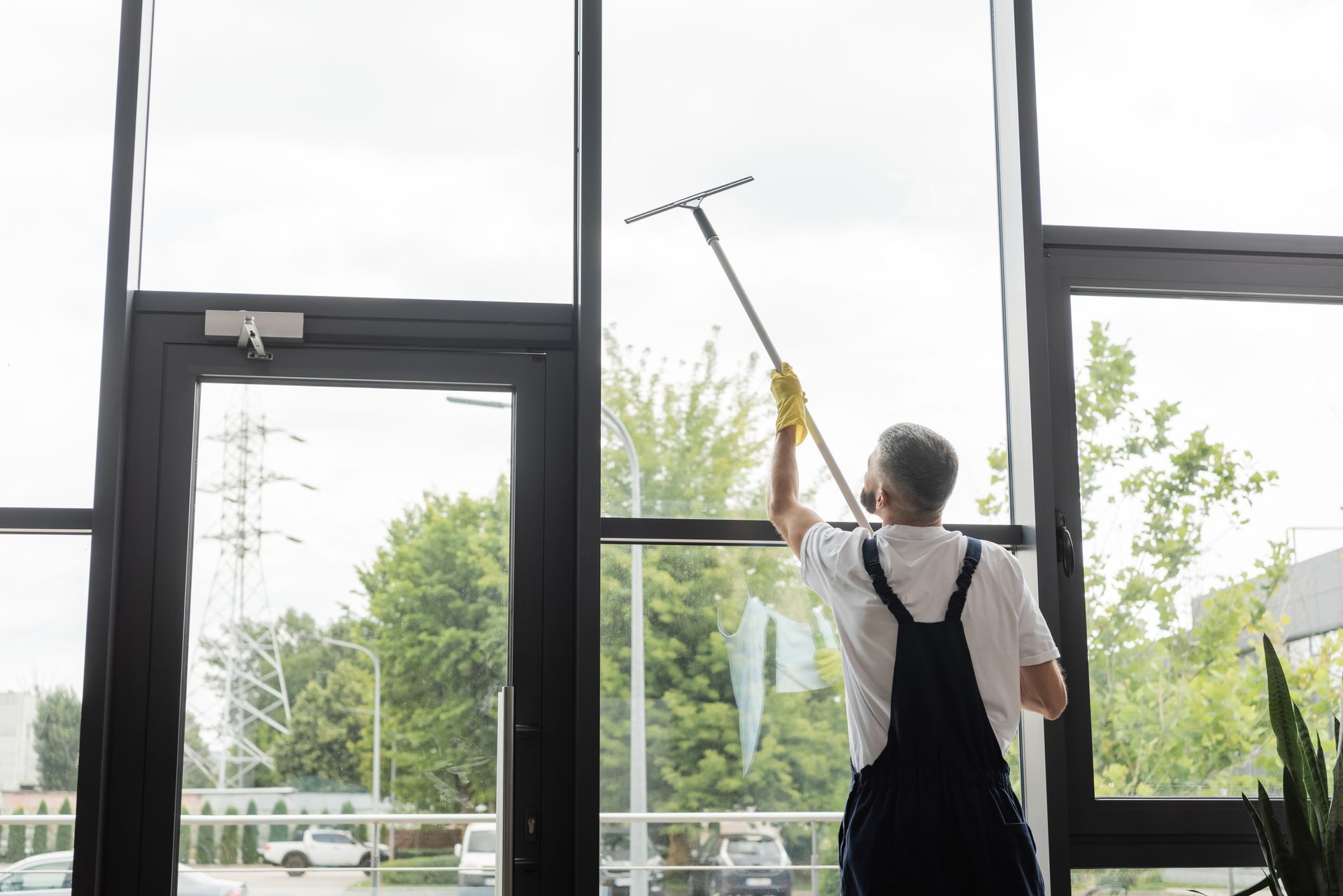 A man is cleaning a window with a squeegee.