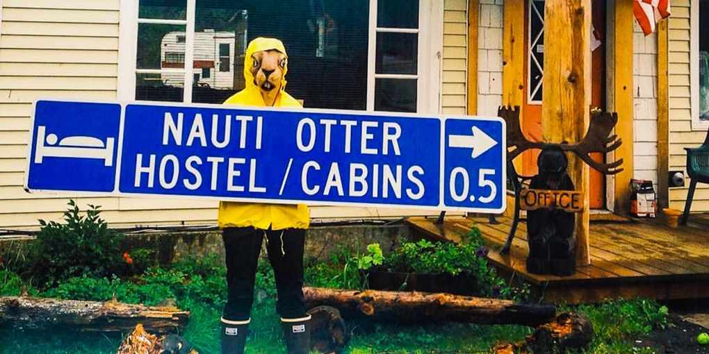Person in yellow raincoat holding a sign for