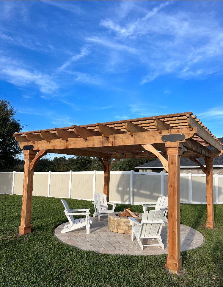 A wooden pergola with chairs and a fire pit in a backyard.
