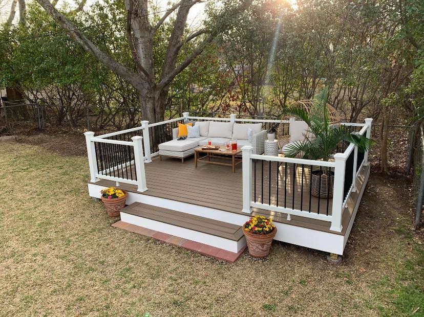 A wooden deck with a white railing and a couch on it.