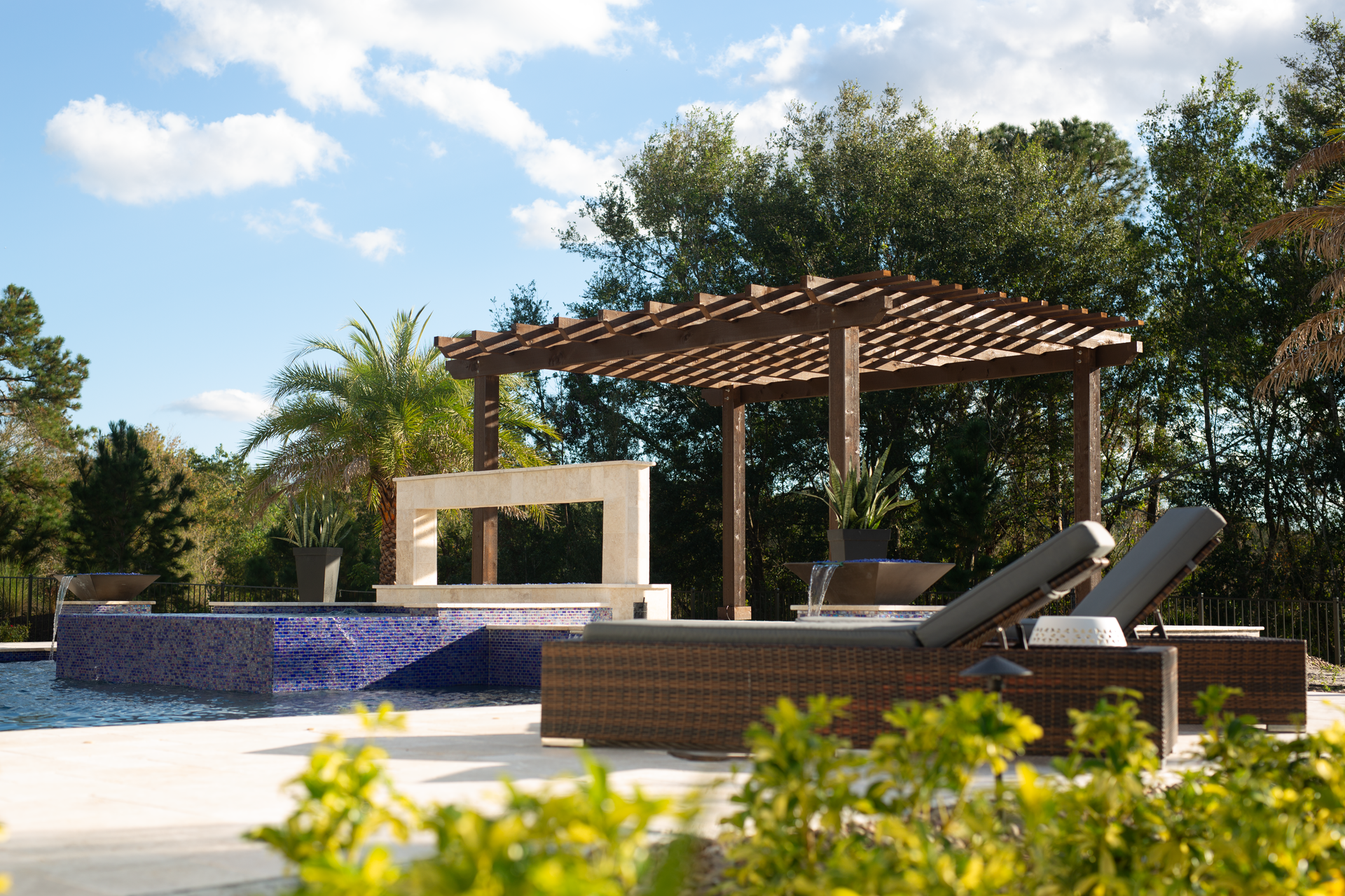 A swimming pool with a pergola and chairs around it