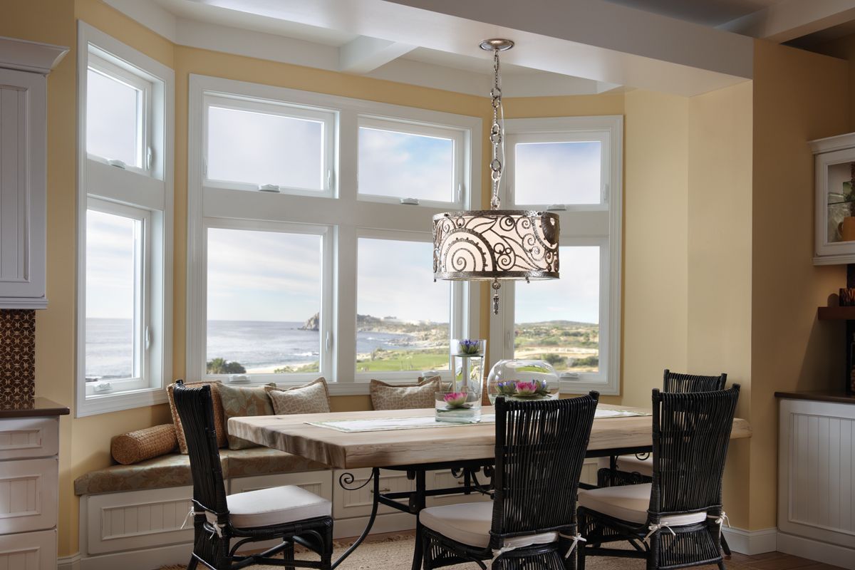 A dining room with a table and chairs and a large window