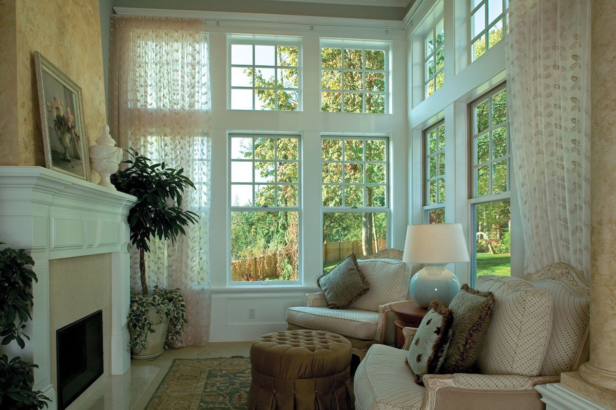 A living room with a lot of windows and a fireplace.