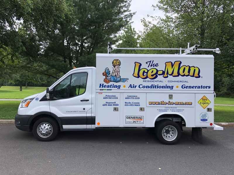 White service van for “The Ice-Man” heating, air conditioning and generators parked by trees.