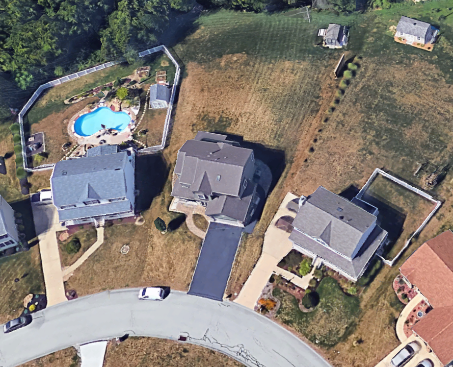 An aerial view of a residential area with houses and a pool