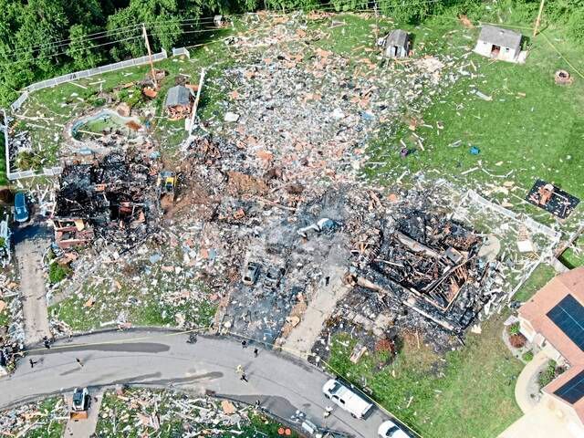 An aerial view of a residential area with houses and a pool destroyed by natural gas explosion