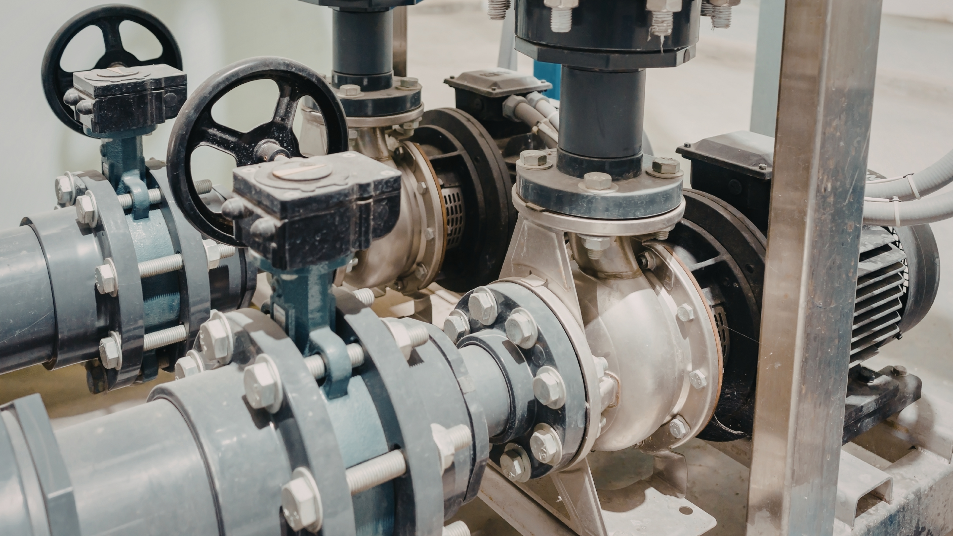 Industrial pumps and pipes with valves in a mechanical plant room
