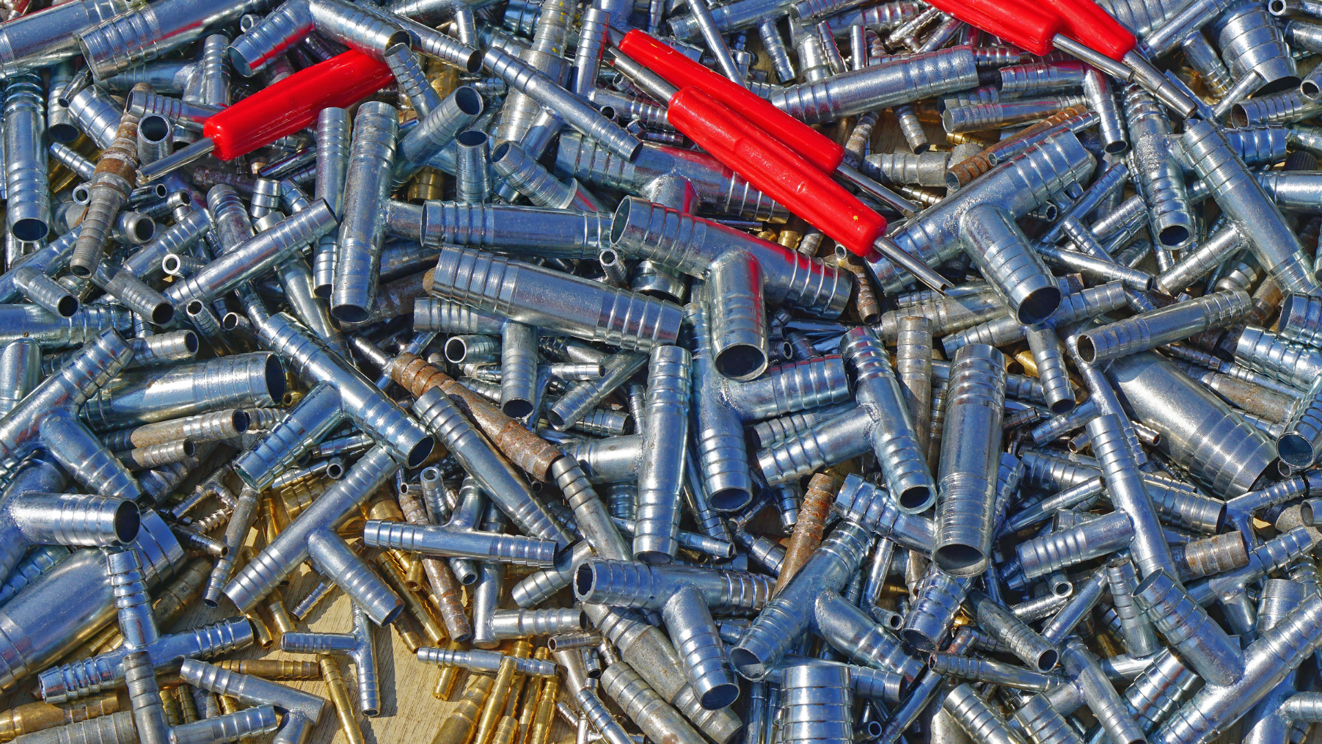 Pile of blue, silver, and red plastic wall anchors scattered on a surface