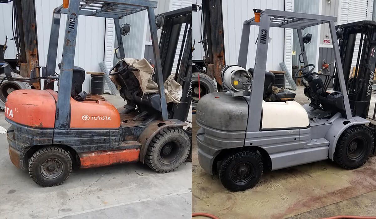 Two forklifts are parked next to each other in front of a building.