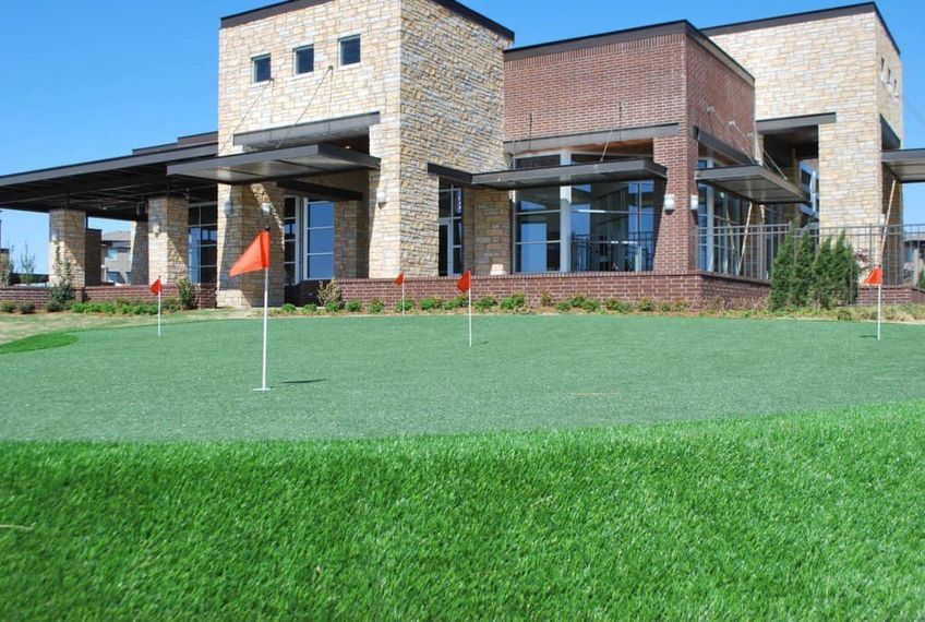 A large building with a golf course in front of it.