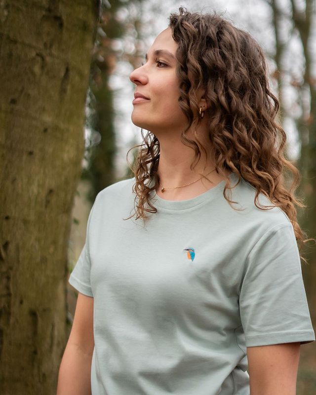 Frau im Wald mit einem bestickten T-Shirt aus Bio-Baumwolle