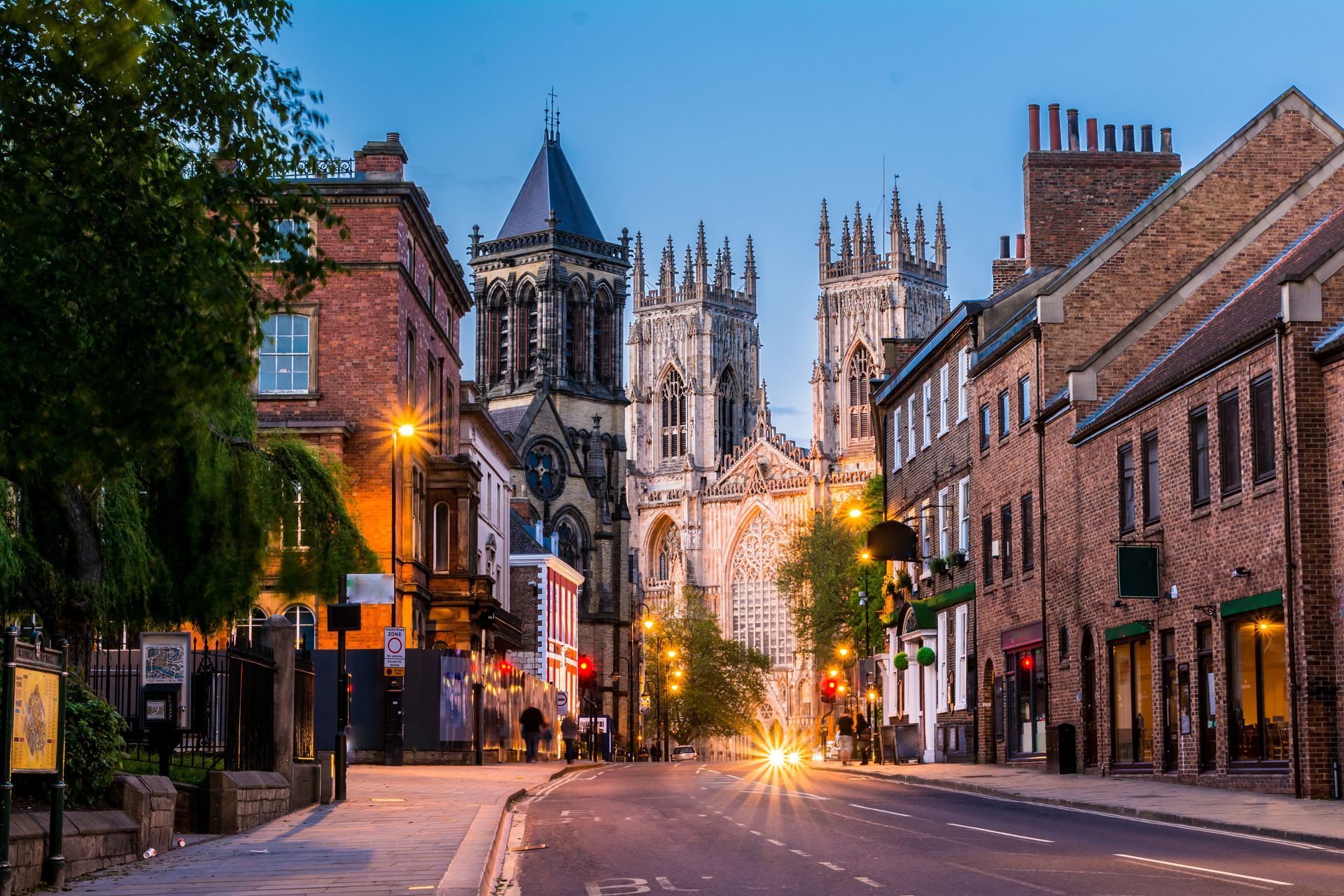 A city street with a large cathedral in the background.