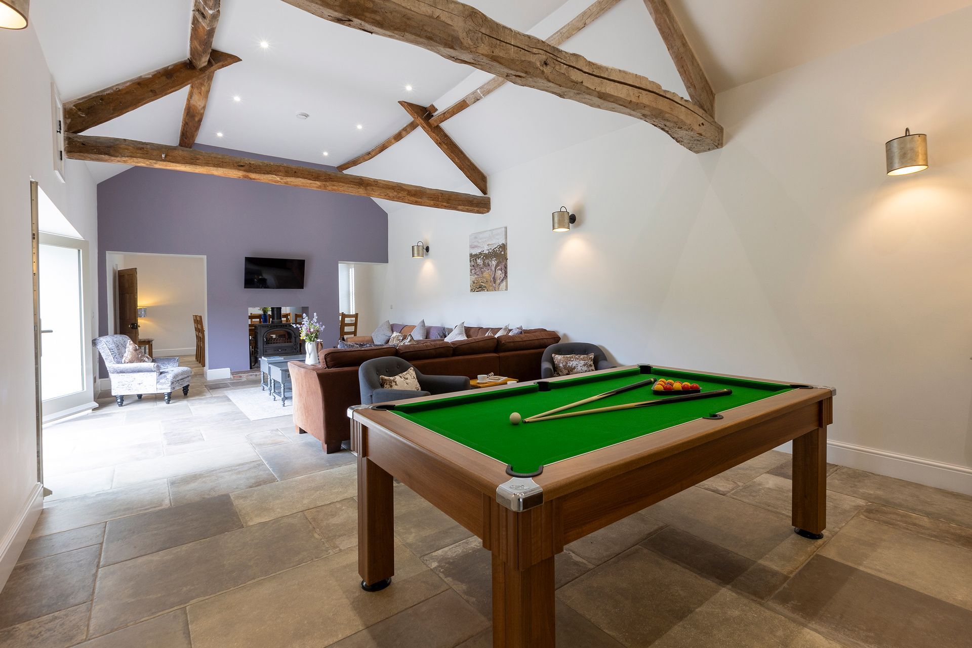 pool table and living room with exposed beams