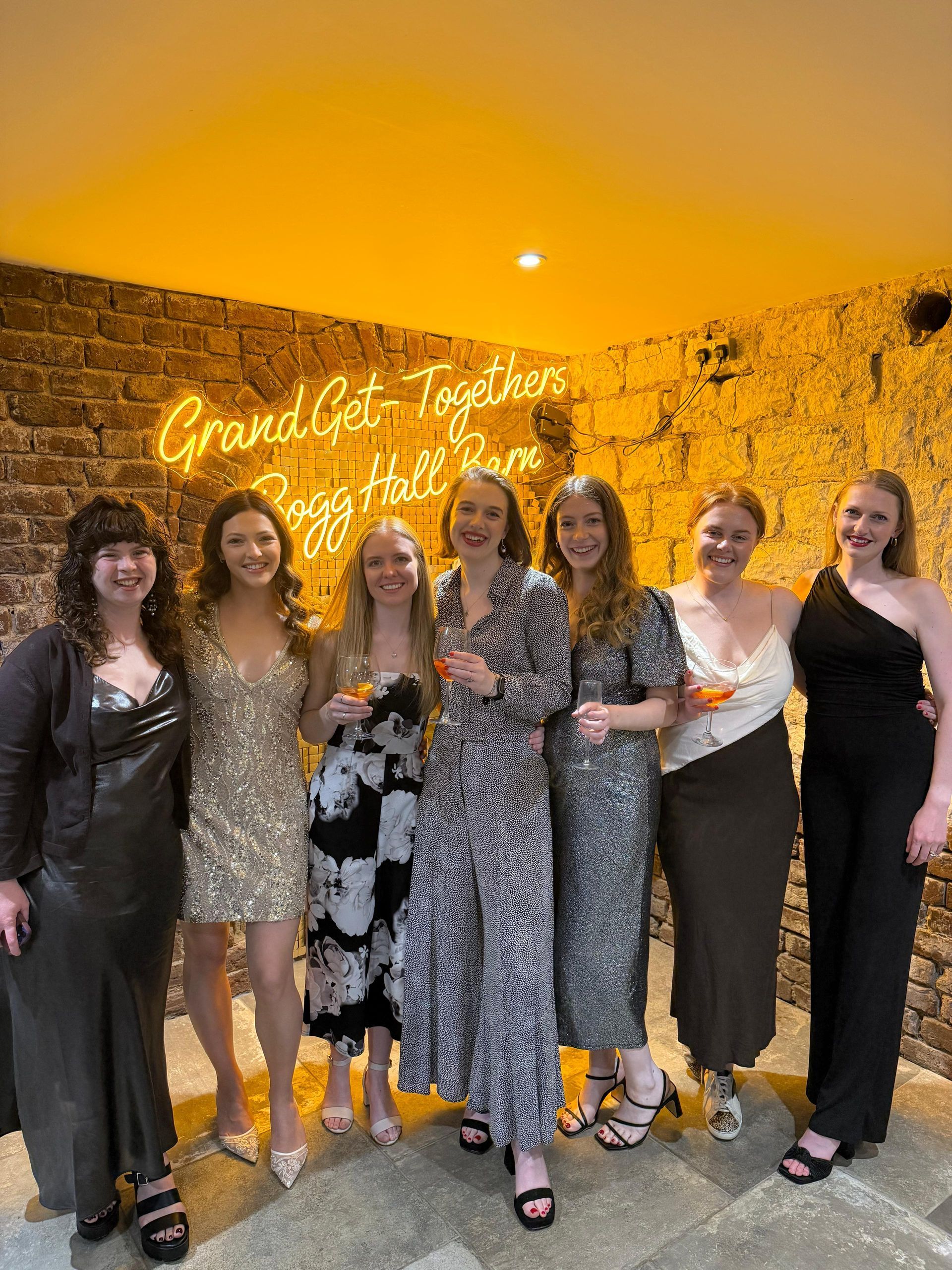 Bride to be and girls in front of Bogg Hall Barn neon sign