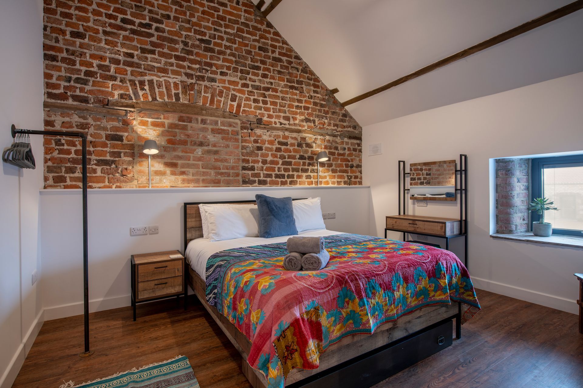 A bedroom with a king size bed and a window.