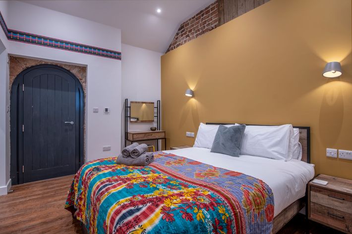 A bedroom with a king size bed , nightstand , chair and desk.