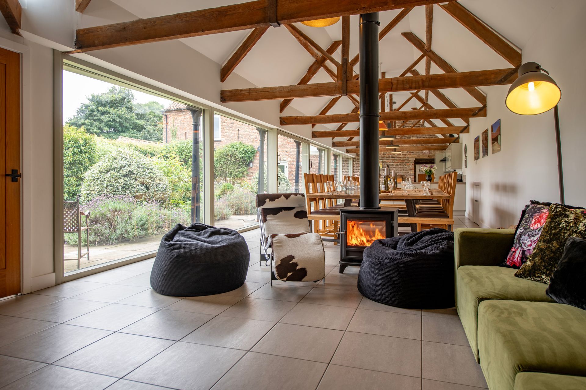 open plan living and dining room with double sided log burner