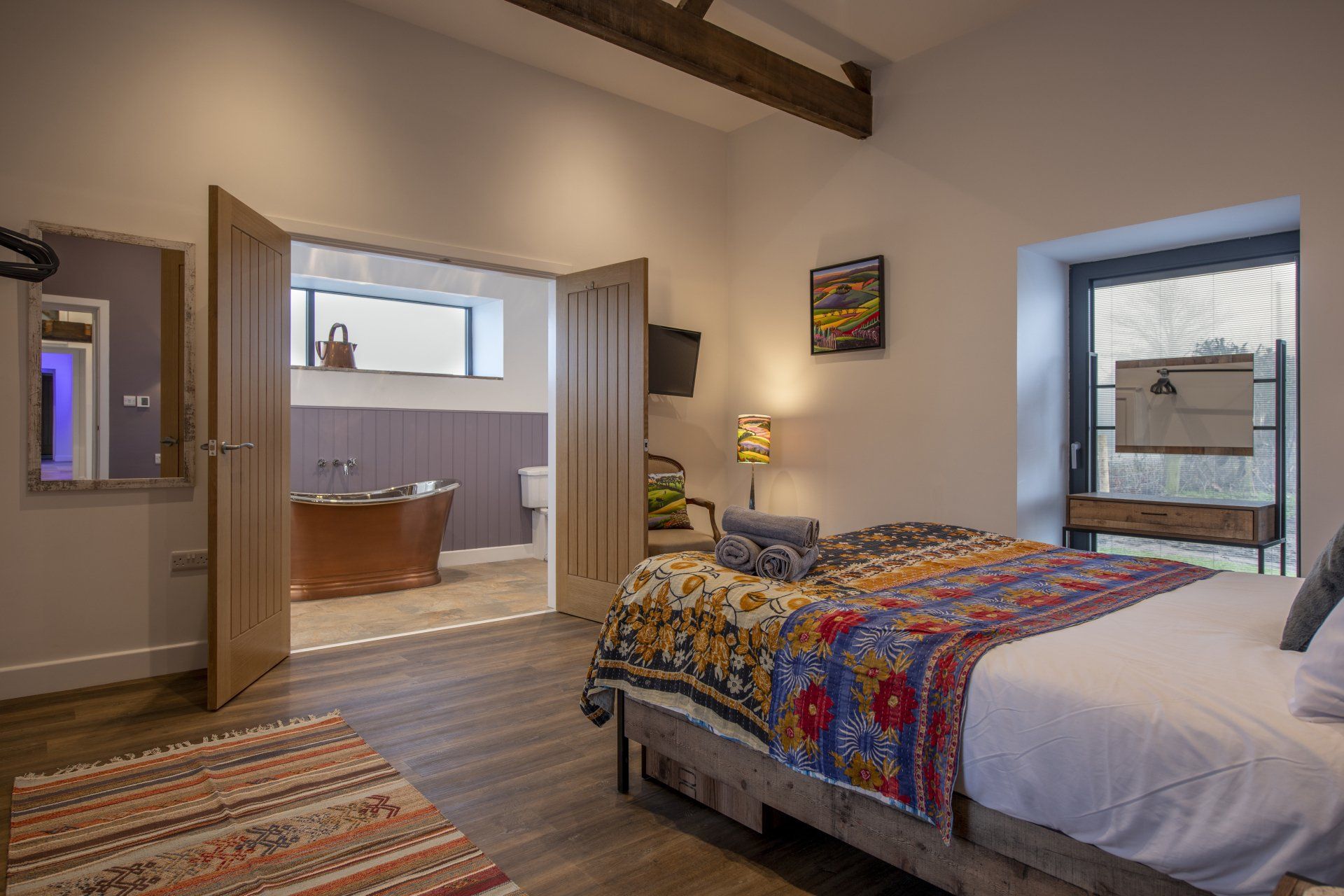 A bedroom with a king size bed and a bathtub.