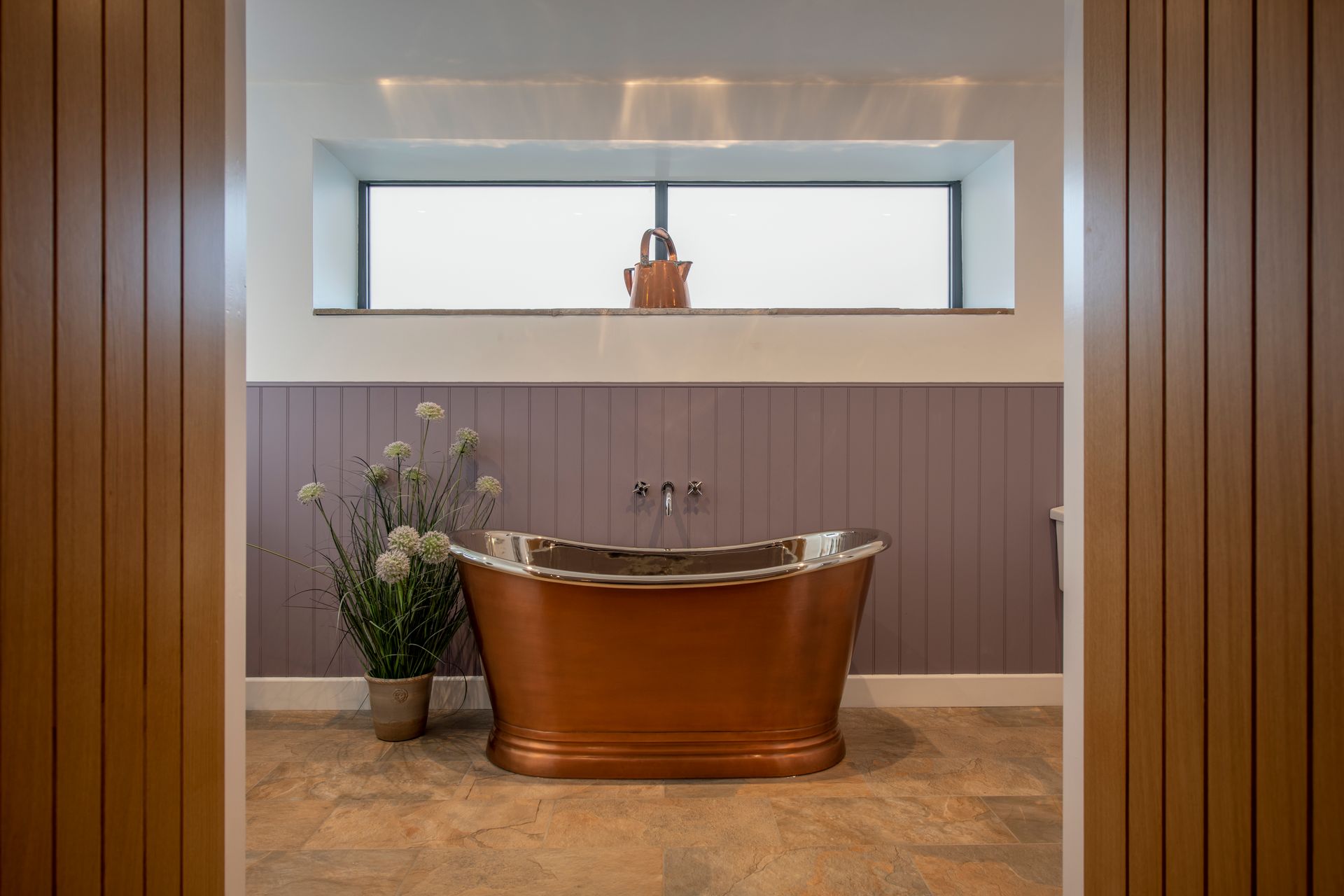 A bathroom with a toilet , sink and mirror.