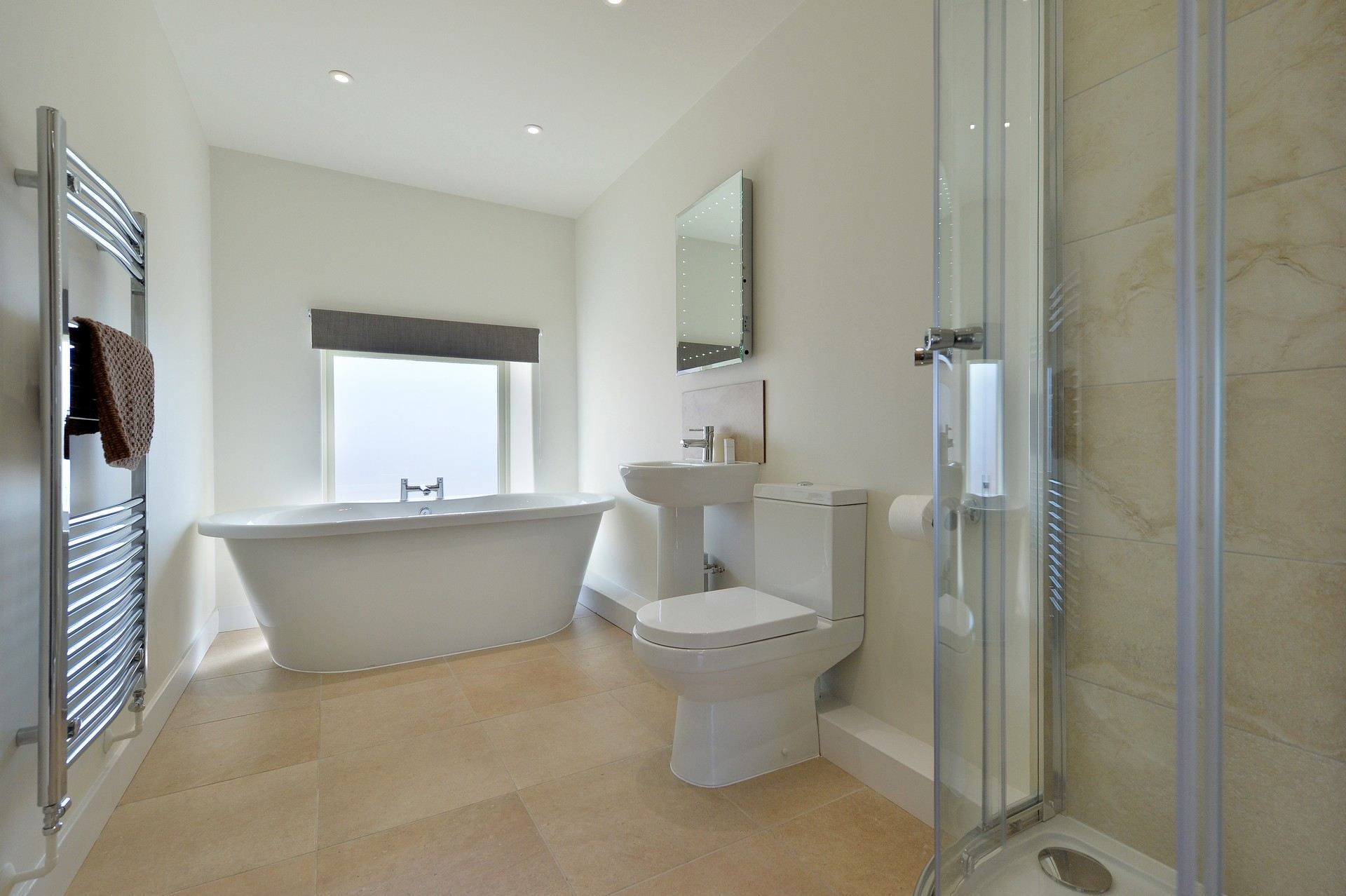 A bathroom with a toilet , sink and walk in shower.