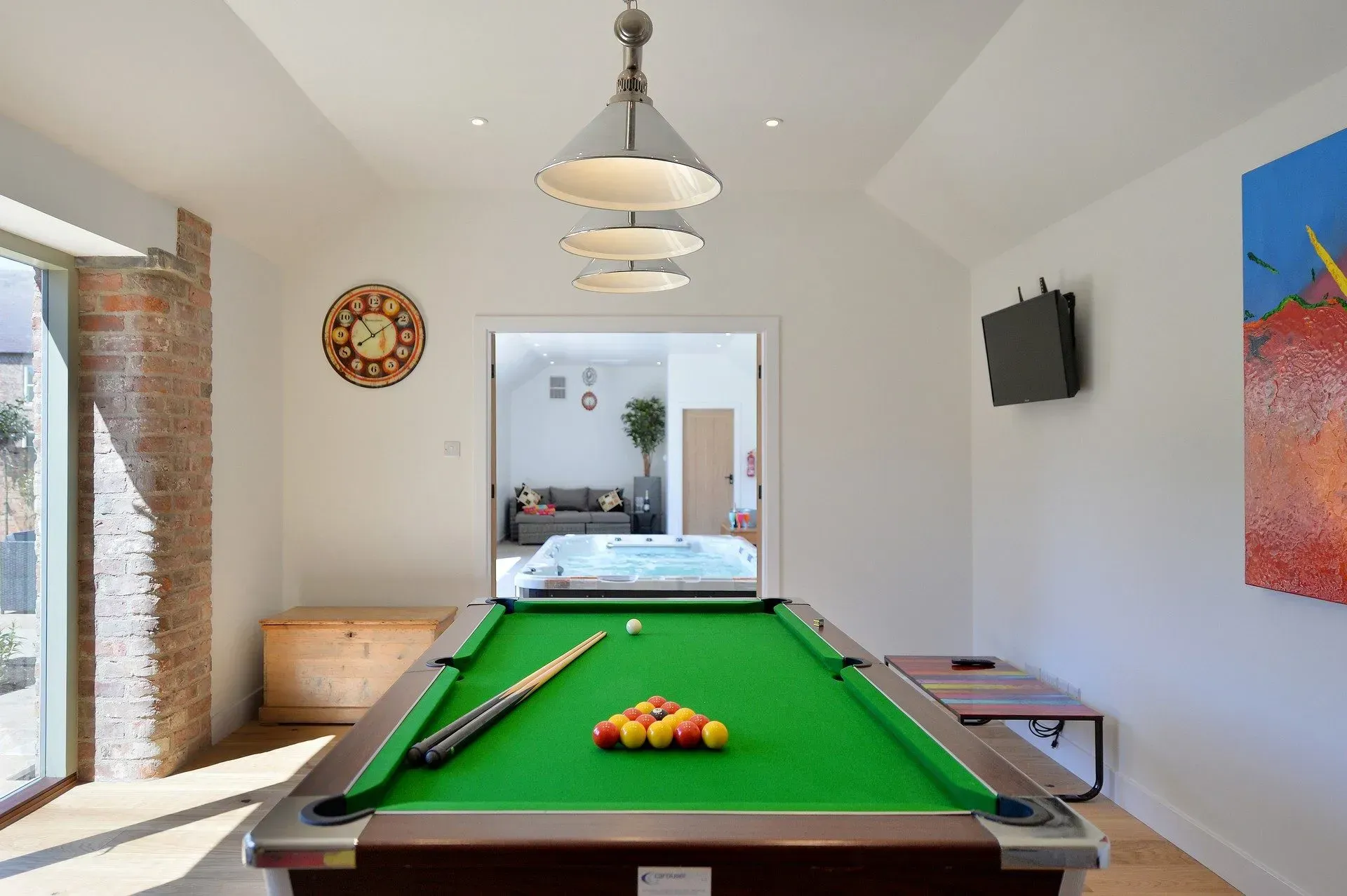 A pool table with cues and balls on it in a room.