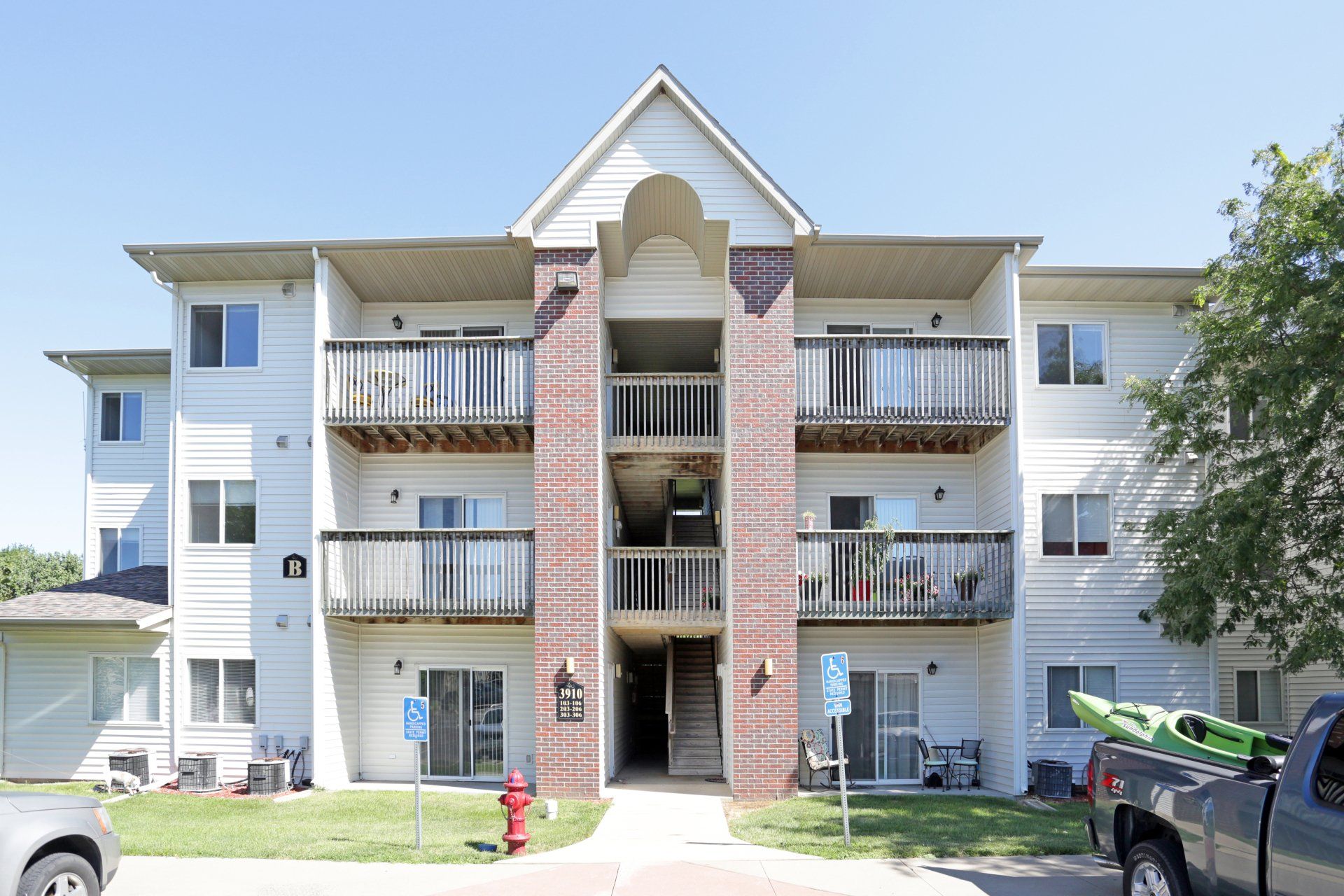 Head-on view of Lynwood Apartment Homes with grass walkway to entrance