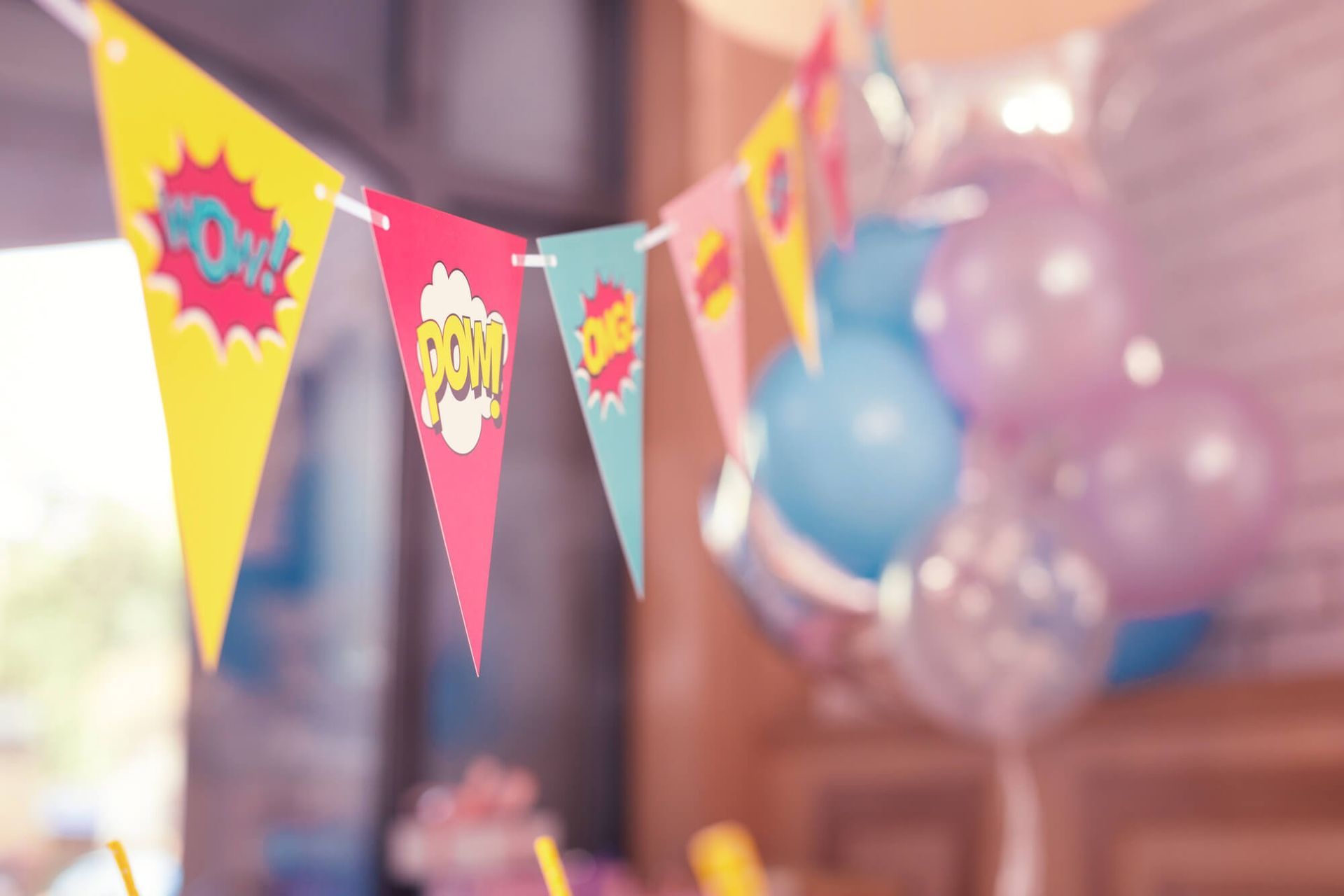 Un montón de banderas y globos cuelgan del techo en una fiesta de cumpleaños.