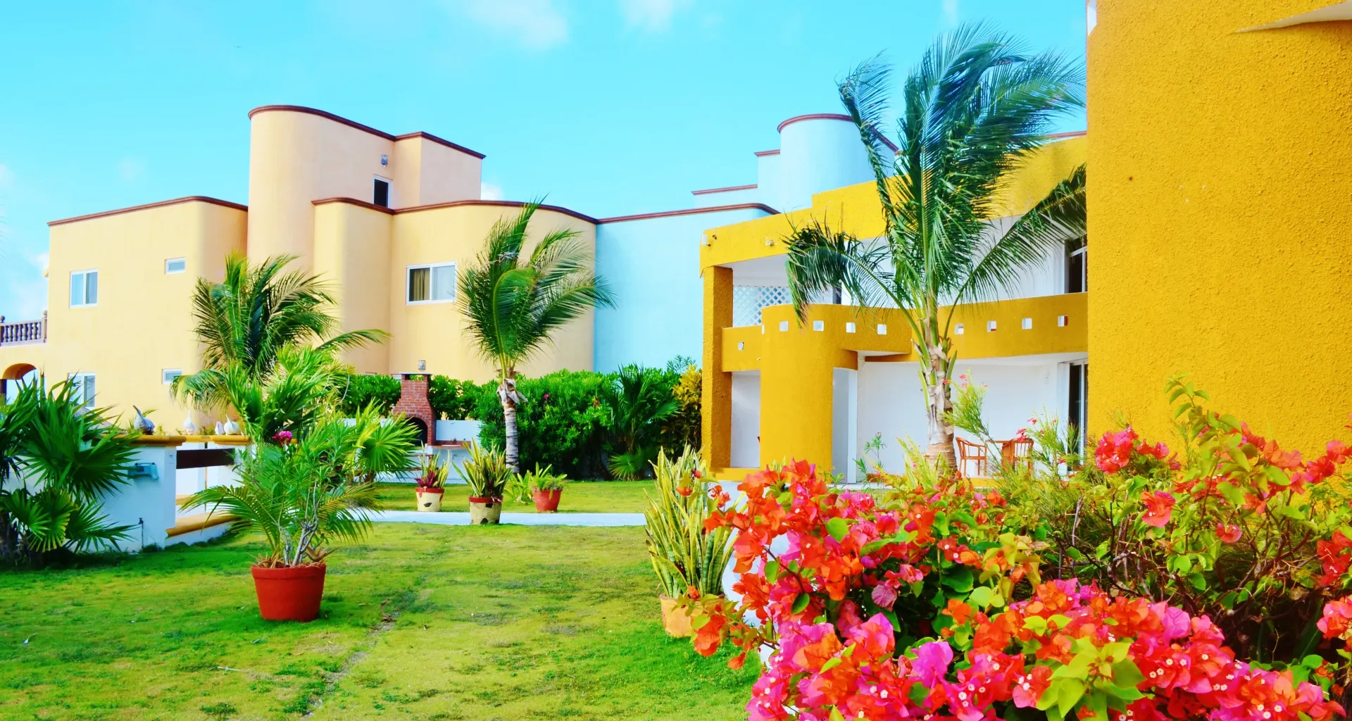 Edificios de resort coloridos con jardines y cielo azul.